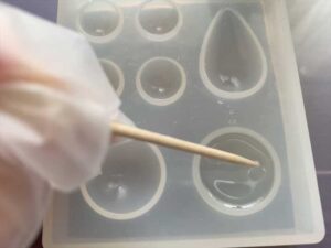 爪楊枝を使ってレジン液を型全体に広げる